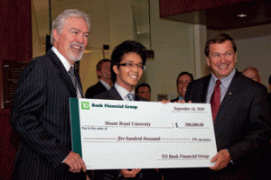 Photo by Bryan Weismiller. The ceremonial larger-than-life cheque is presented to Dave Marshall, left, and Bissett School of Business graduate Mario Chao, centre, by TD deputy chair Frank McKenna.