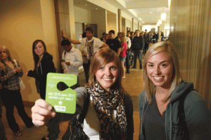 Photo by Josh Naud. Erin Summers, left, with Rebecca Kuresh, shows off her parking pass after braving the lengthy pick-up line at the parking office on Sept. 7.