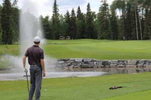 Local golfer Ryan Hounjet stares down his second shot at the par 5 18th hole at Priddis Greens Golf and Country Club | Photo by Brendan Stasiewich